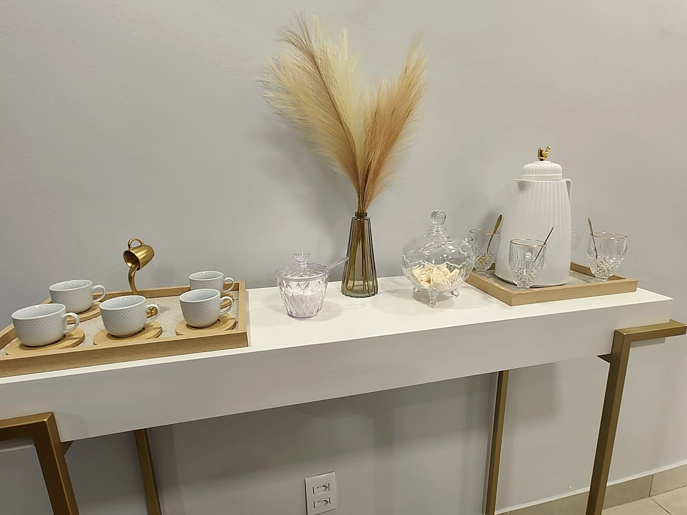 Cantinho do café com xícaras, garrafa térmica e capim dos pampas